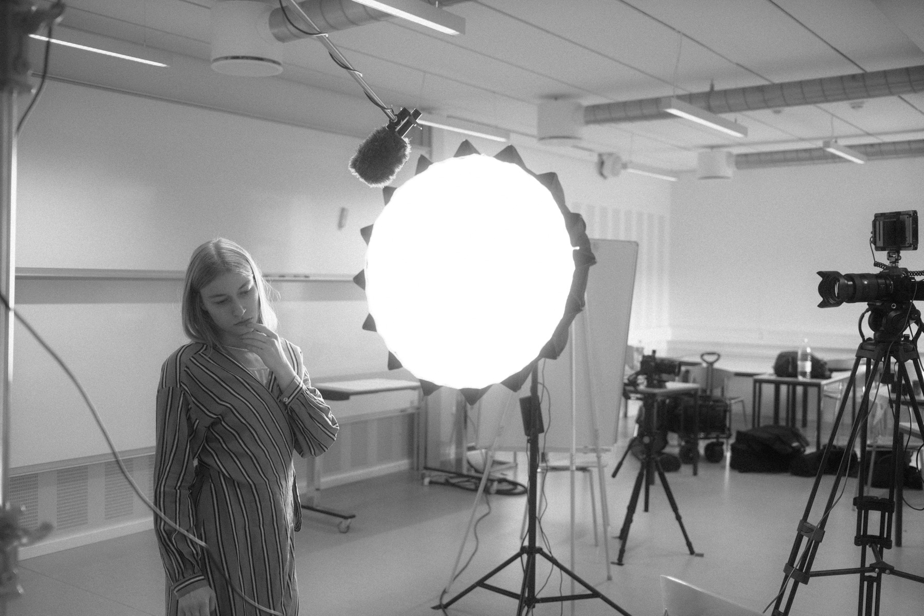 Bag kameraet på et filmset — softbox, boom og medvirkende